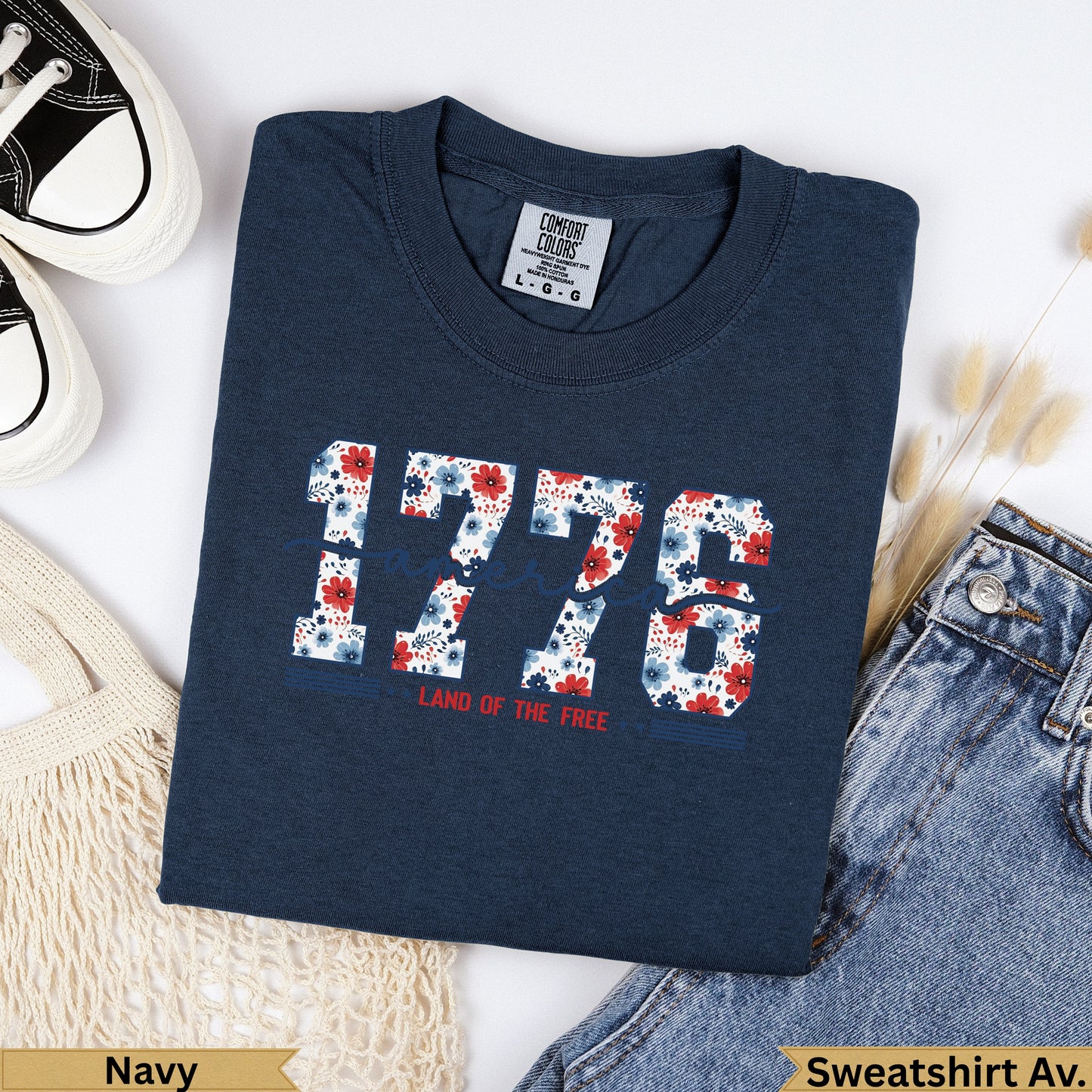 Navy t-shirt with "1776 LAND OF THE FREE" in red, white, and blue floral print.