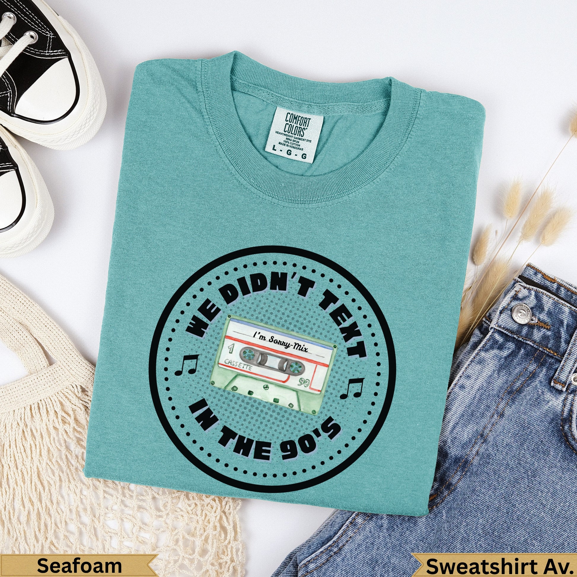 Teal crewneck sweatshirt with "We Didn't Text In The 90s" and cassette tape graphic.