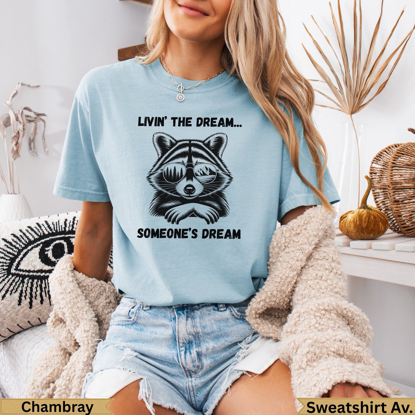 Light blue t-shirt with raccoon wearing sunglasses and text "Livin' the dream... someone's dream".