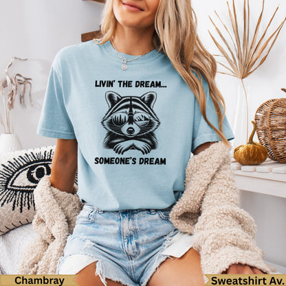 Light blue t-shirt with raccoon wearing sunglasses and text "Livin' the dream... someone's dream".
