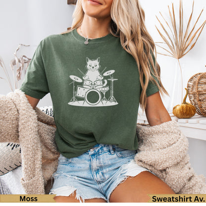 Cat drummer on drum set, dark green t-shirt.