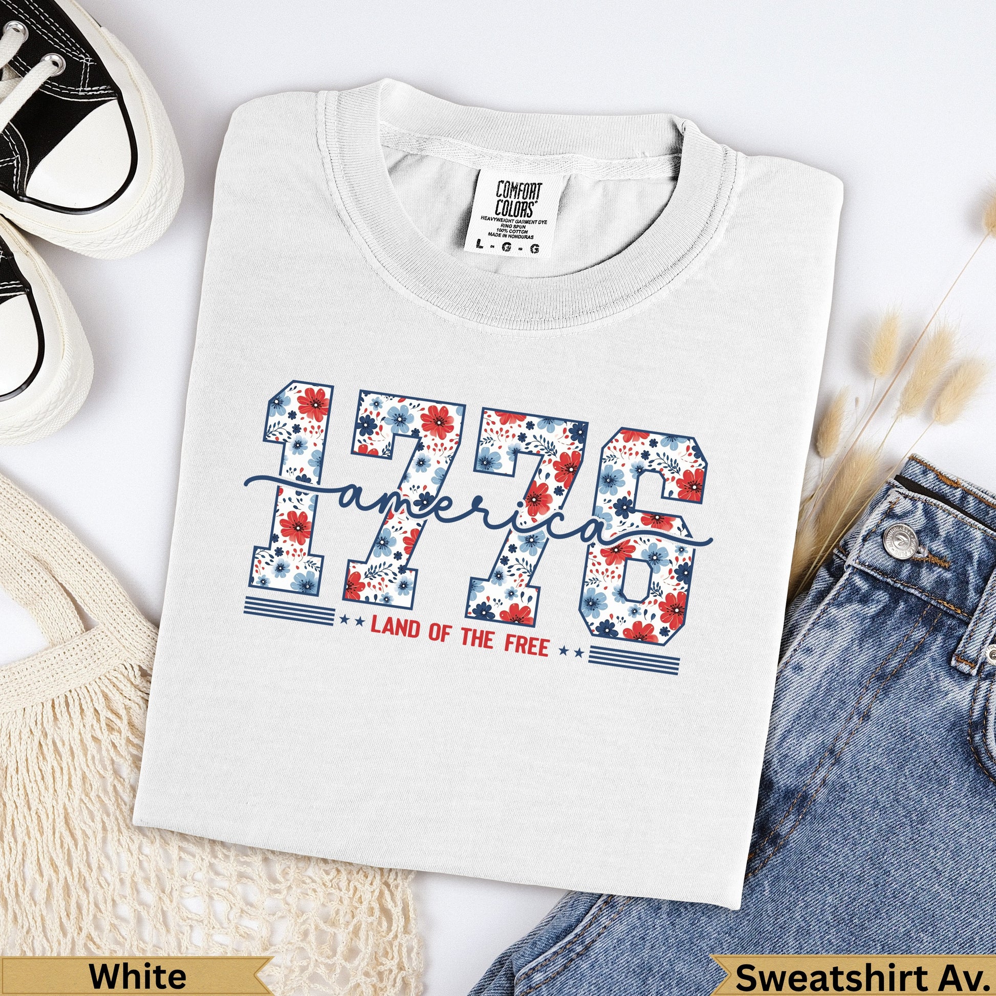 White t-shirt with "1776 LAND OF THE FREE" in floral lettering.