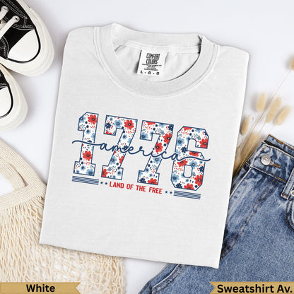White t-shirt with "1776 LAND OF THE FREE" in floral lettering.