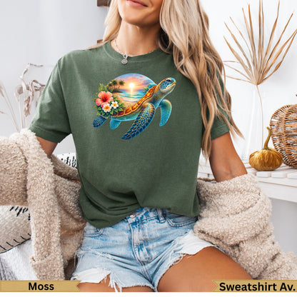 Green t-shirt with a colorful sea turtle and sunset beach scene design.