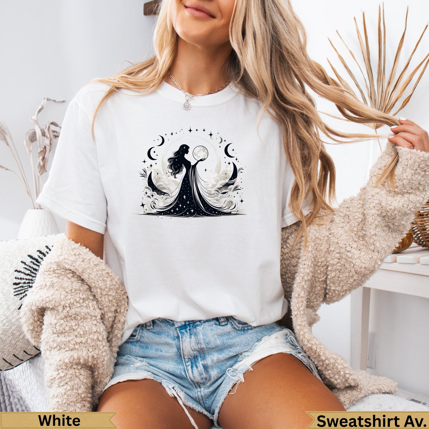 Woman wearing white t-shirt with celestial moon and star design.
