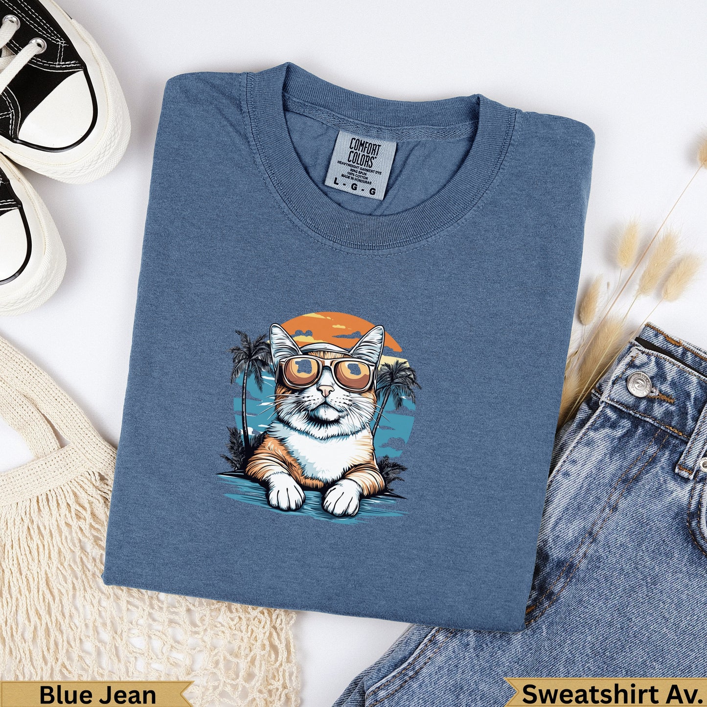 T-shirt with a cat wearing sunglasses and a beach scene design.