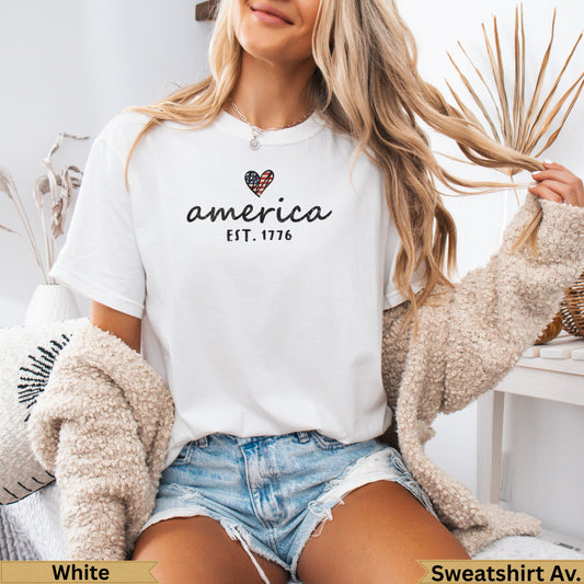 White t-shirt with "America EST. 1776" and heart-shaped flag graphic.