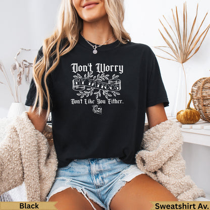 Black t-shirt with "Don't Worry My Tattoos Don't Like You Either" text and skull graphic.
