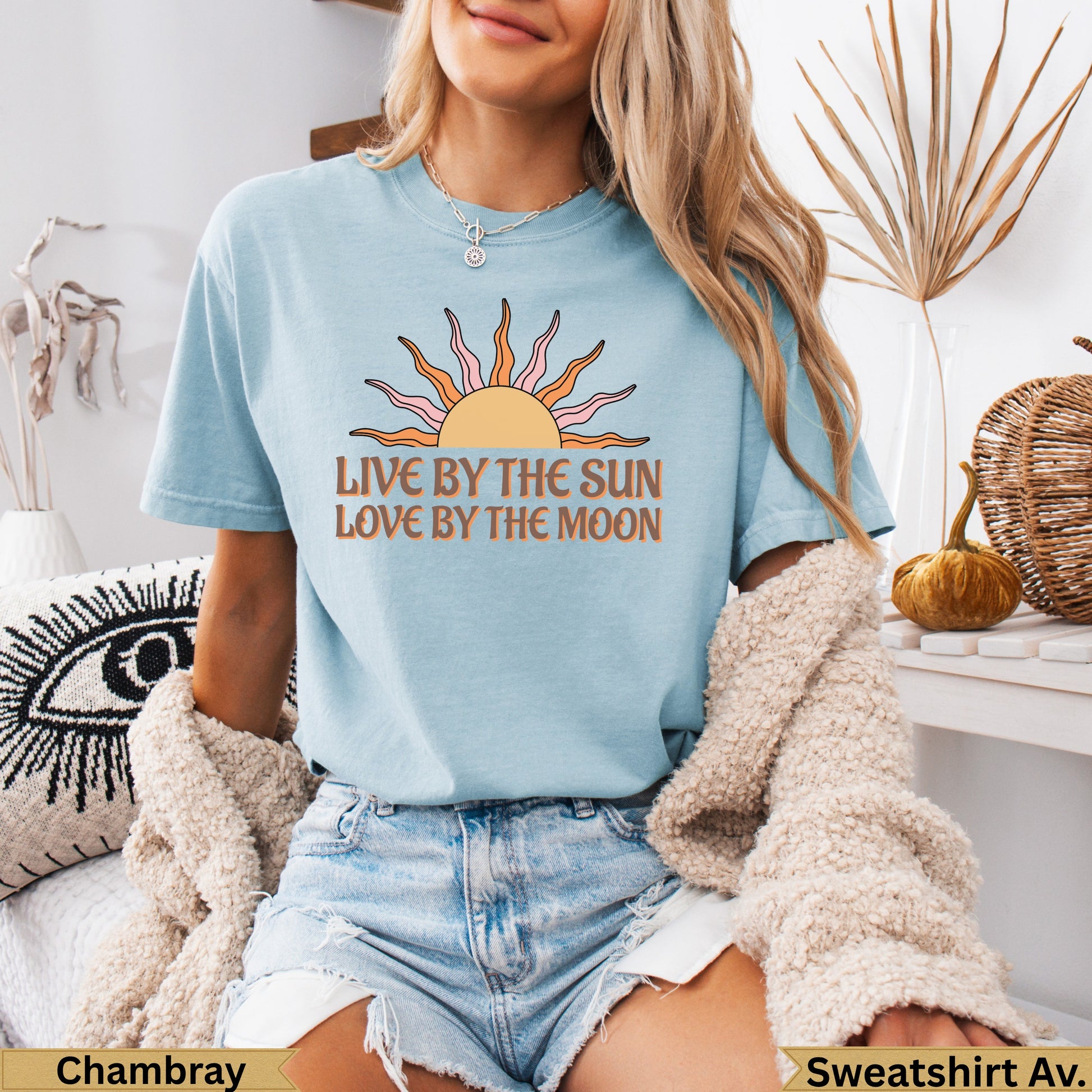 Light blue t-shirt with "Live by the sun, love by the moon" sun graphic.