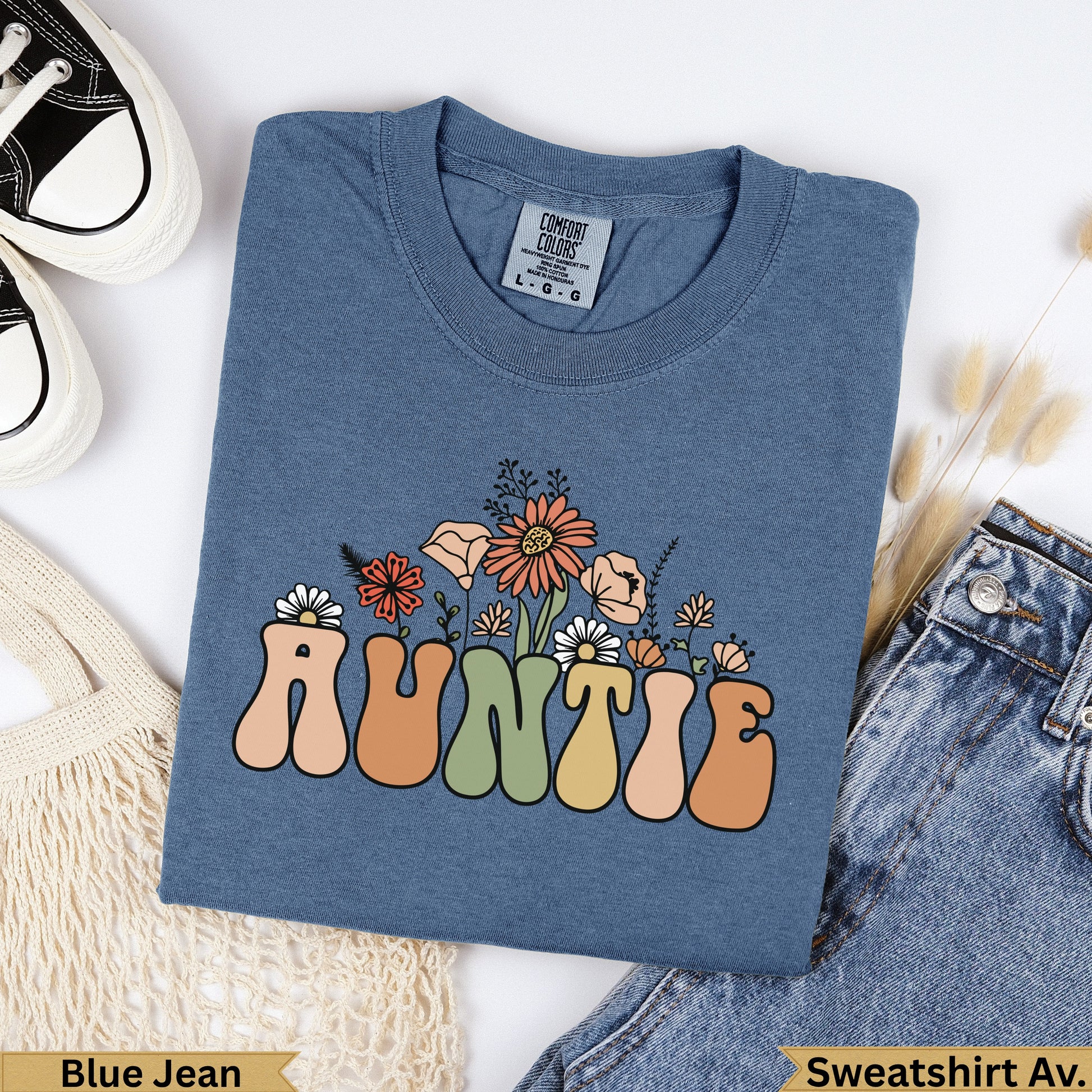 Blue t-shirt with "AUNTIE" in colorful retro lettering and floral accents.