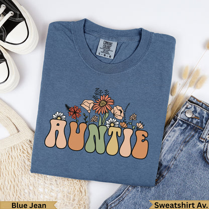 Blue t-shirt with "AUNTIE" in colorful retro lettering and floral accents.