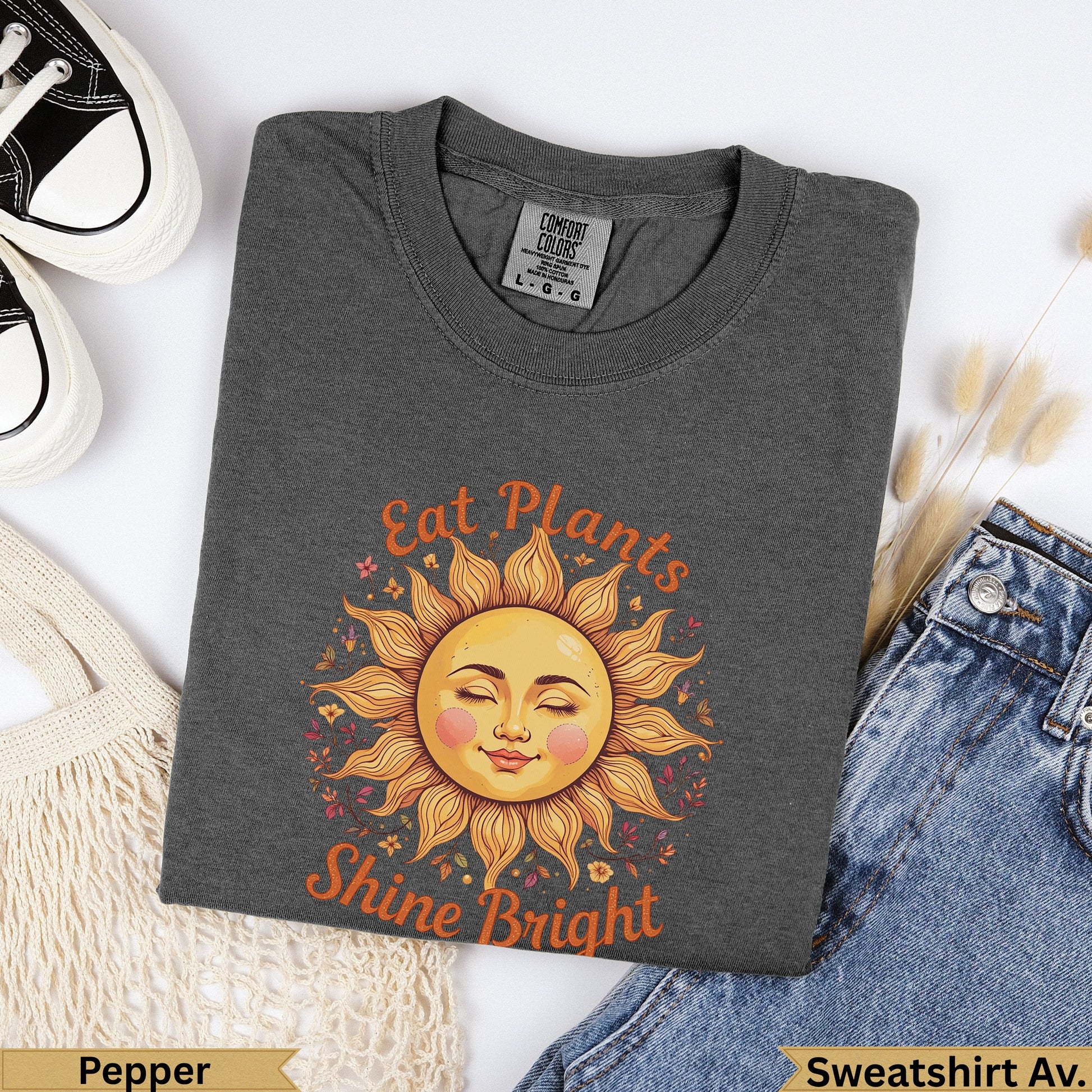 Dark gray t-shirt with smiling sun graphic saying "Eat Plants Shine Bright."