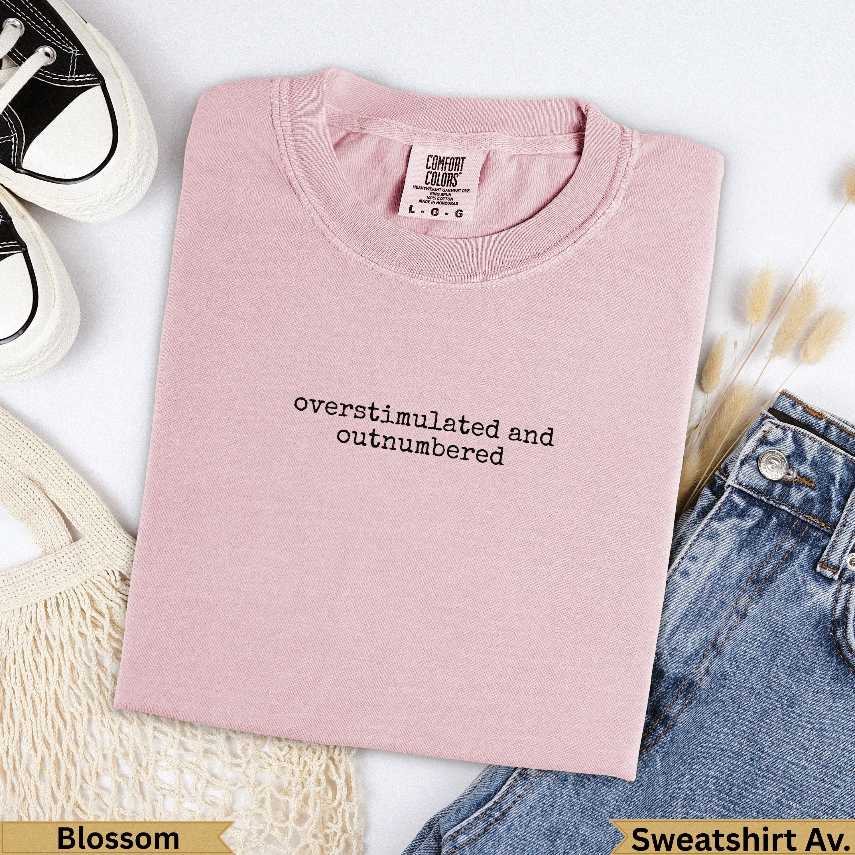 Pink Comfort Colors sweatshirt with "overstimulated and outnumbered" text.