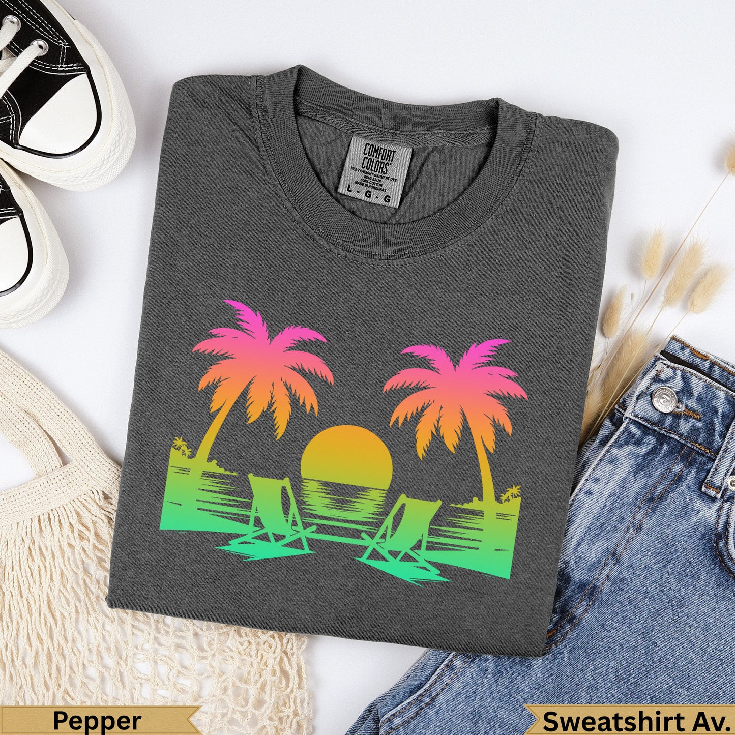 Dark gray t-shirt with sunset, palm trees, and beach chairs graphic.