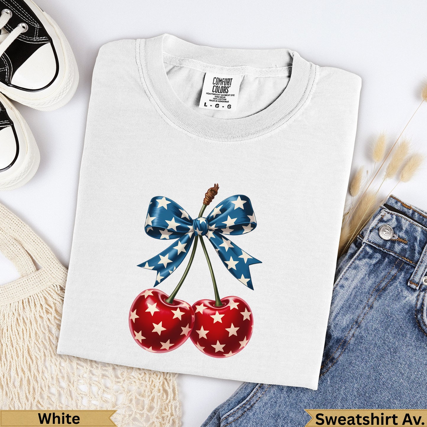 White t-shirt with red cherries and a blue star-spangled ribbon bow.
