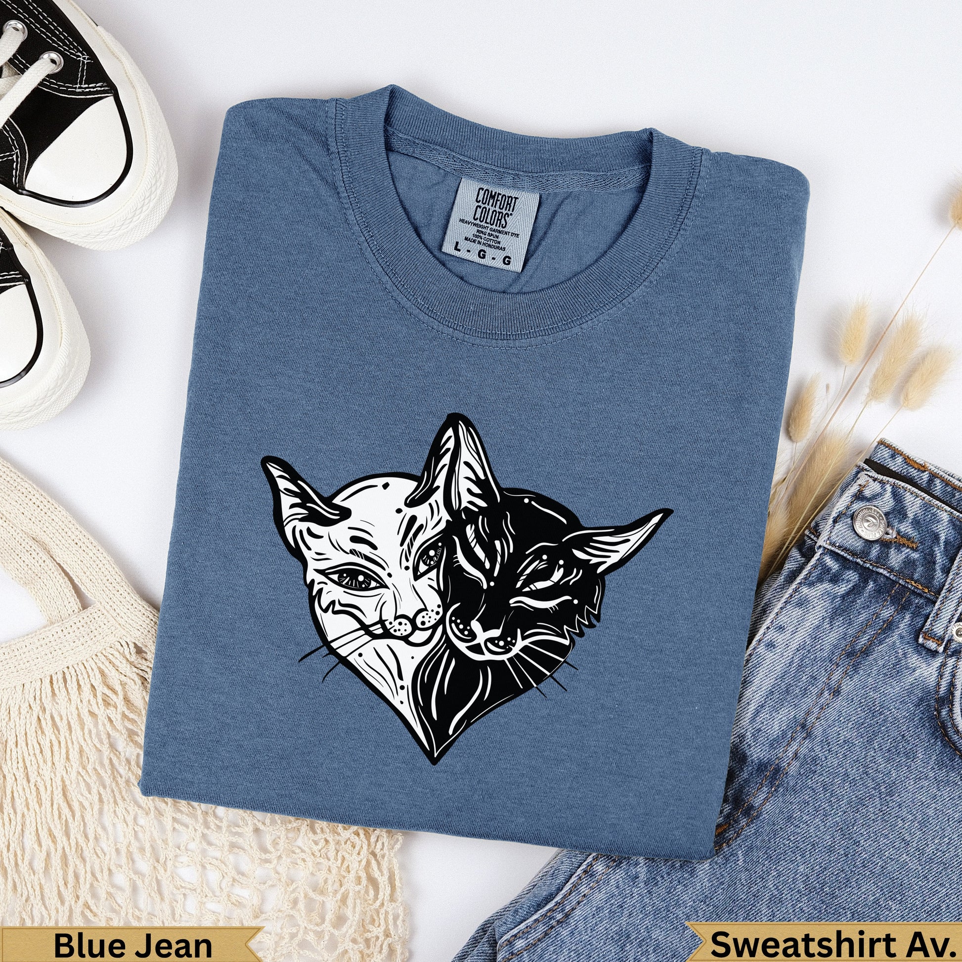 Blue Jean sweatshirt with split black and white cat heart graphic.