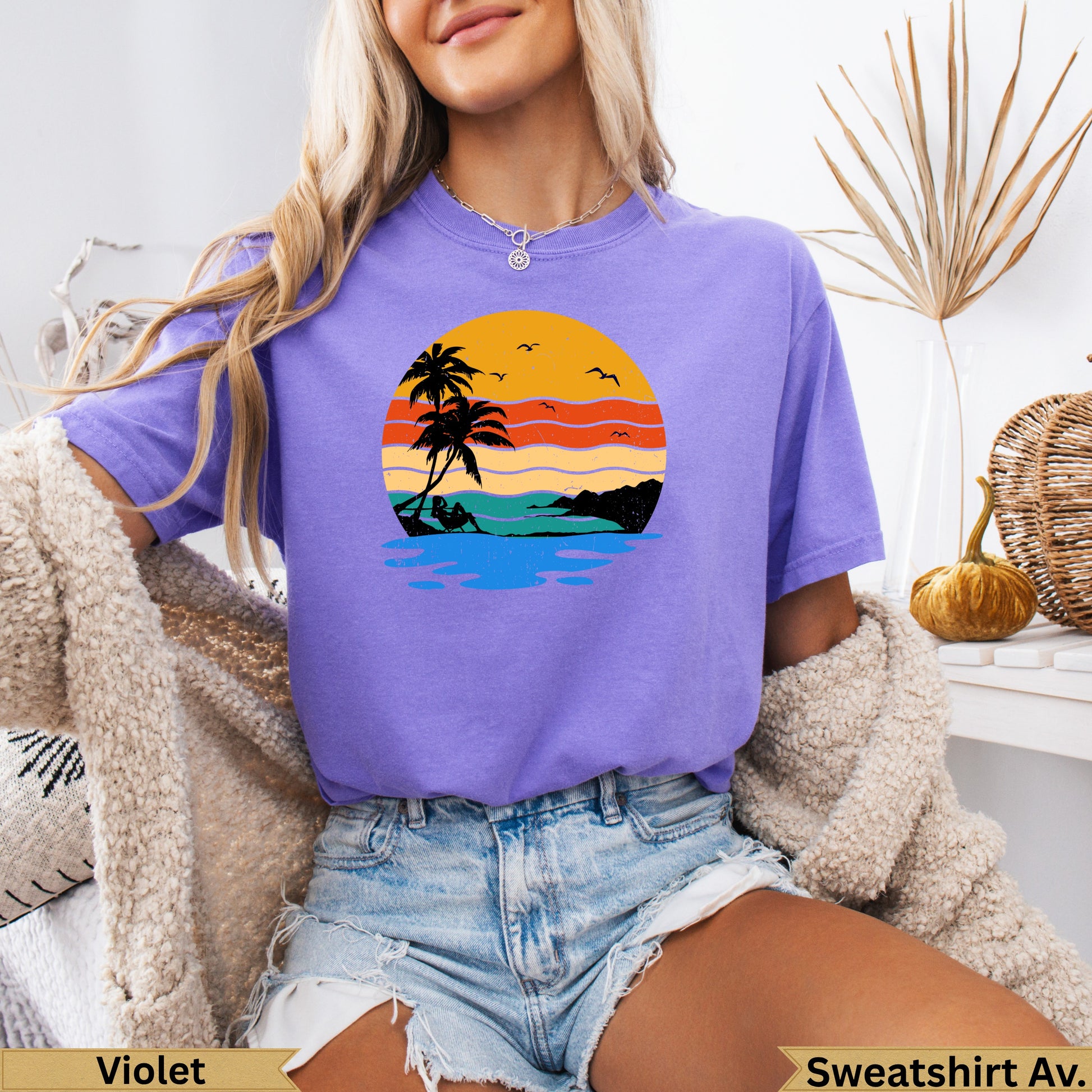 Purple t-shirt with sunset beach graphic and palm trees.