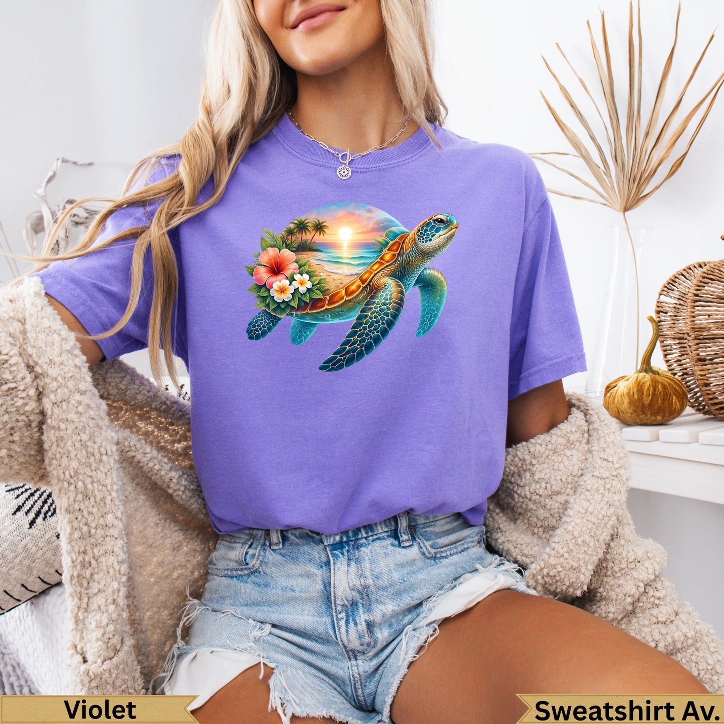 Sea turtle with beach and sunset graphic on a purple t-shirt.