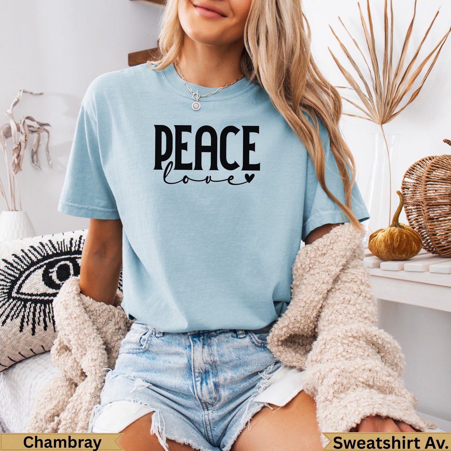 Light blue t-shirt with "PEACE love" text, worn by a woman.