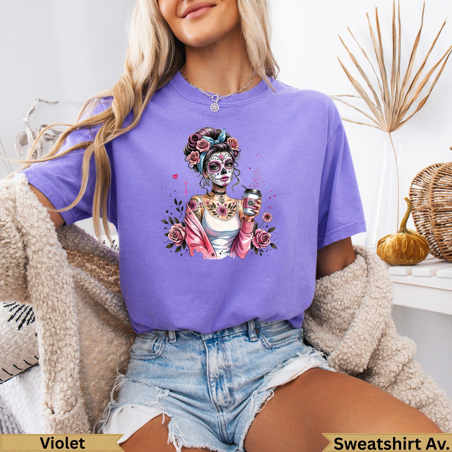 Woman wearing a purple t-shirt with a Day of the Dead inspired skull graphic.