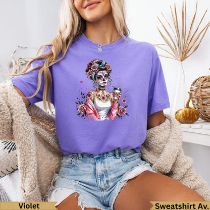 Woman wearing a purple t-shirt with a Day of the Dead inspired skull graphic.
