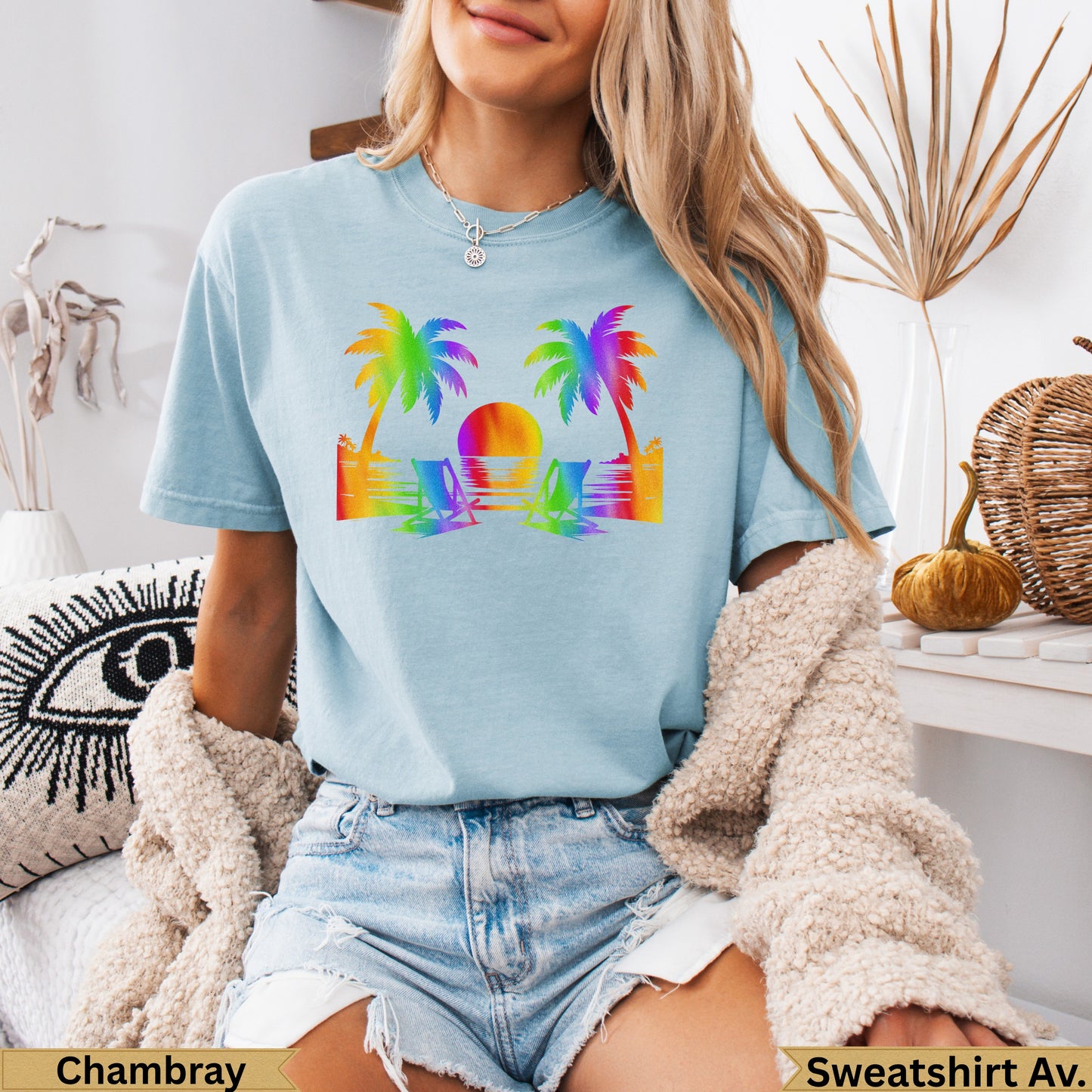 Light blue t-shirt with rainbow sunset beach graphic and palm trees.