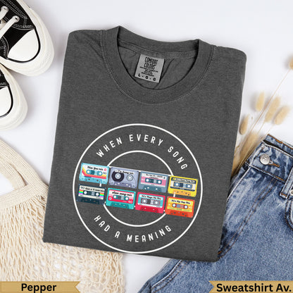 Dark gray sweatshirt with "When Every Song Had a Meaning" and colorful cassette tape graphic.
