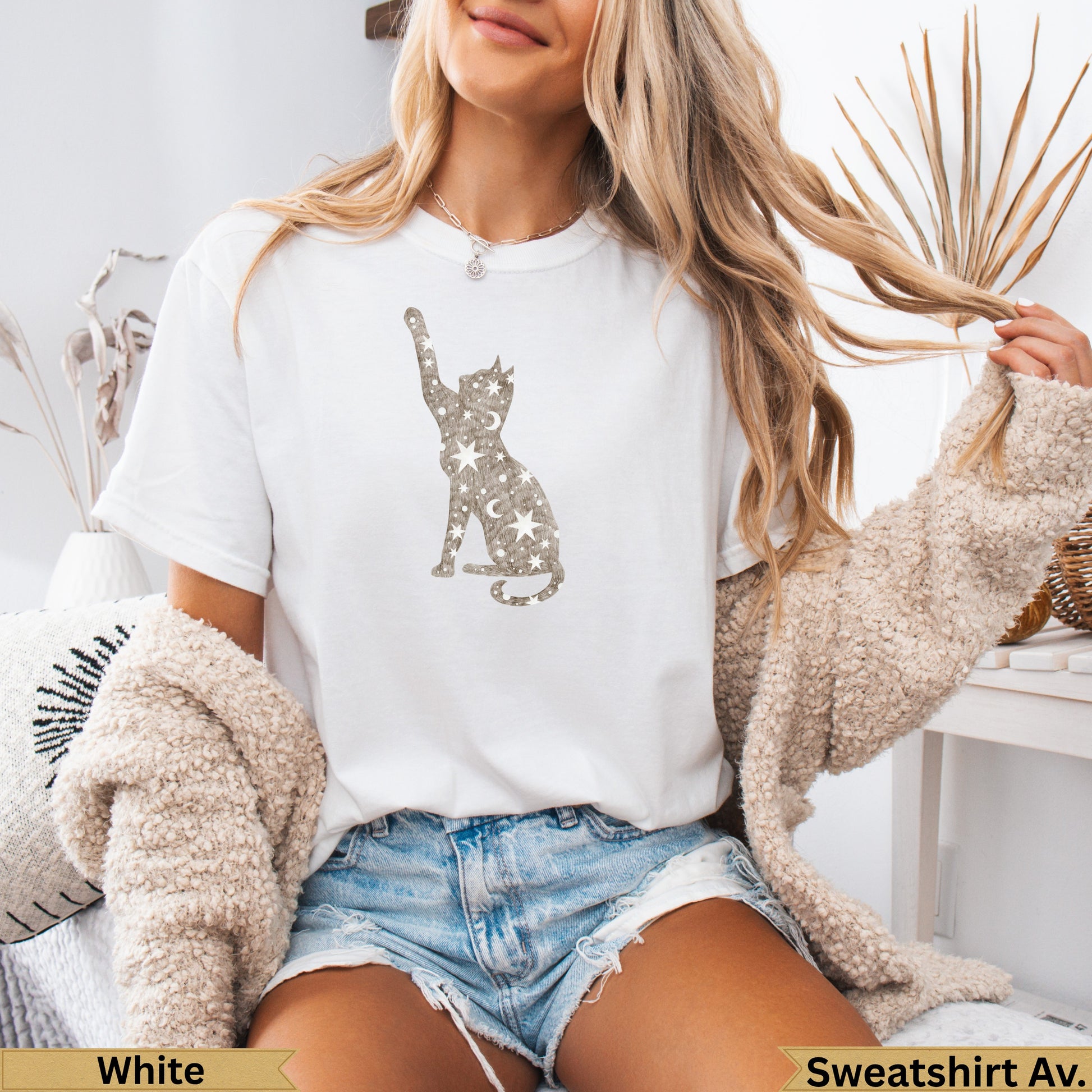 White t-shirt with a glittery cat outline and scattered stars.