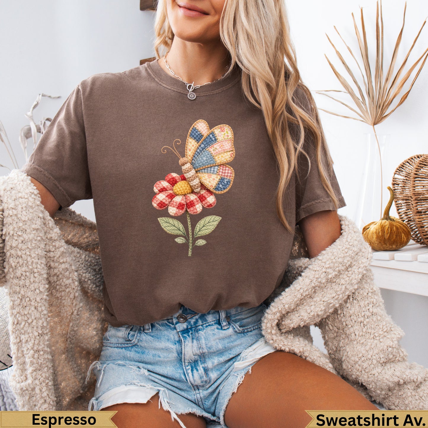 Brown sweatshirt with embroidered butterfly on a floral applique.