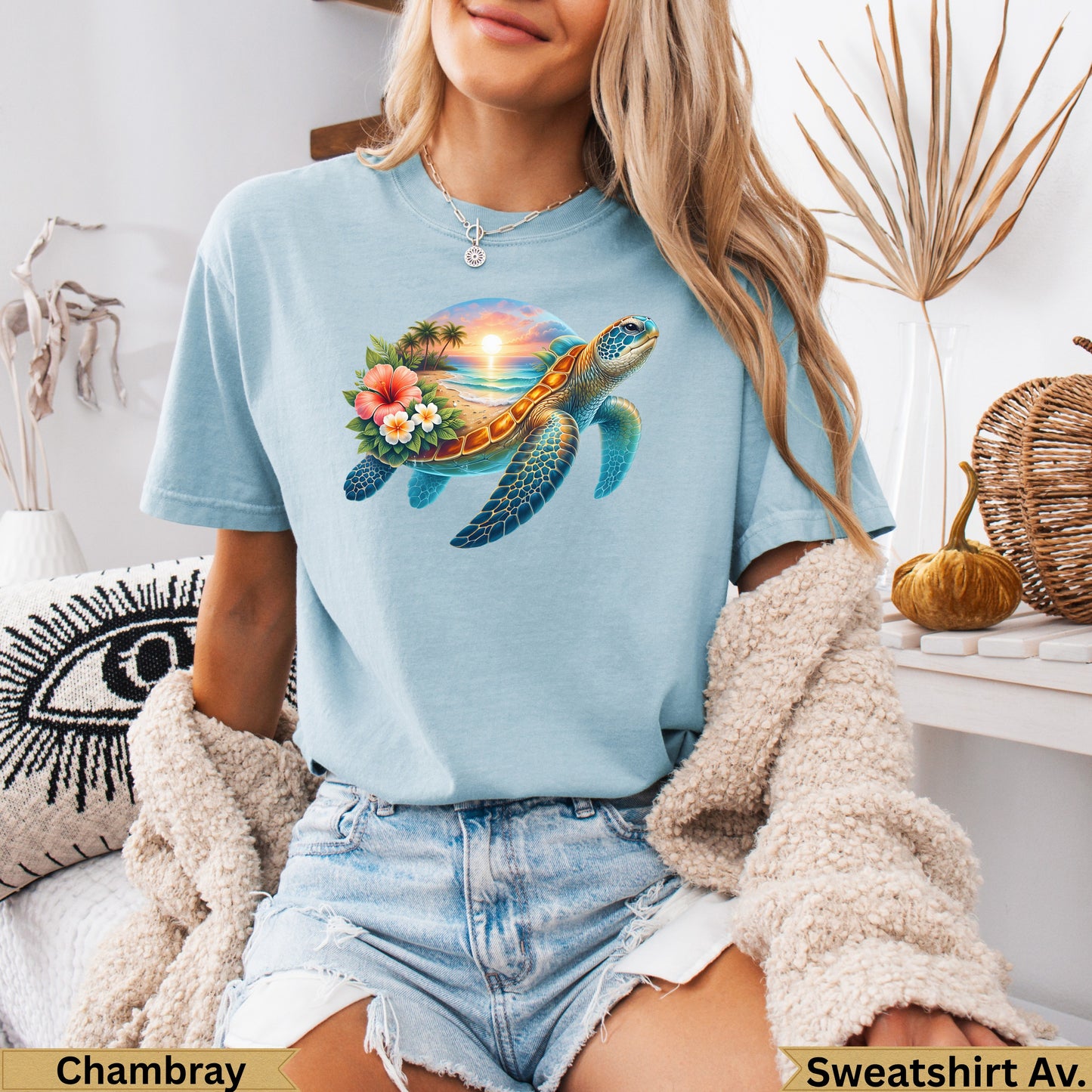 Light blue t-shirt with a sea turtle on a beach at sunset.