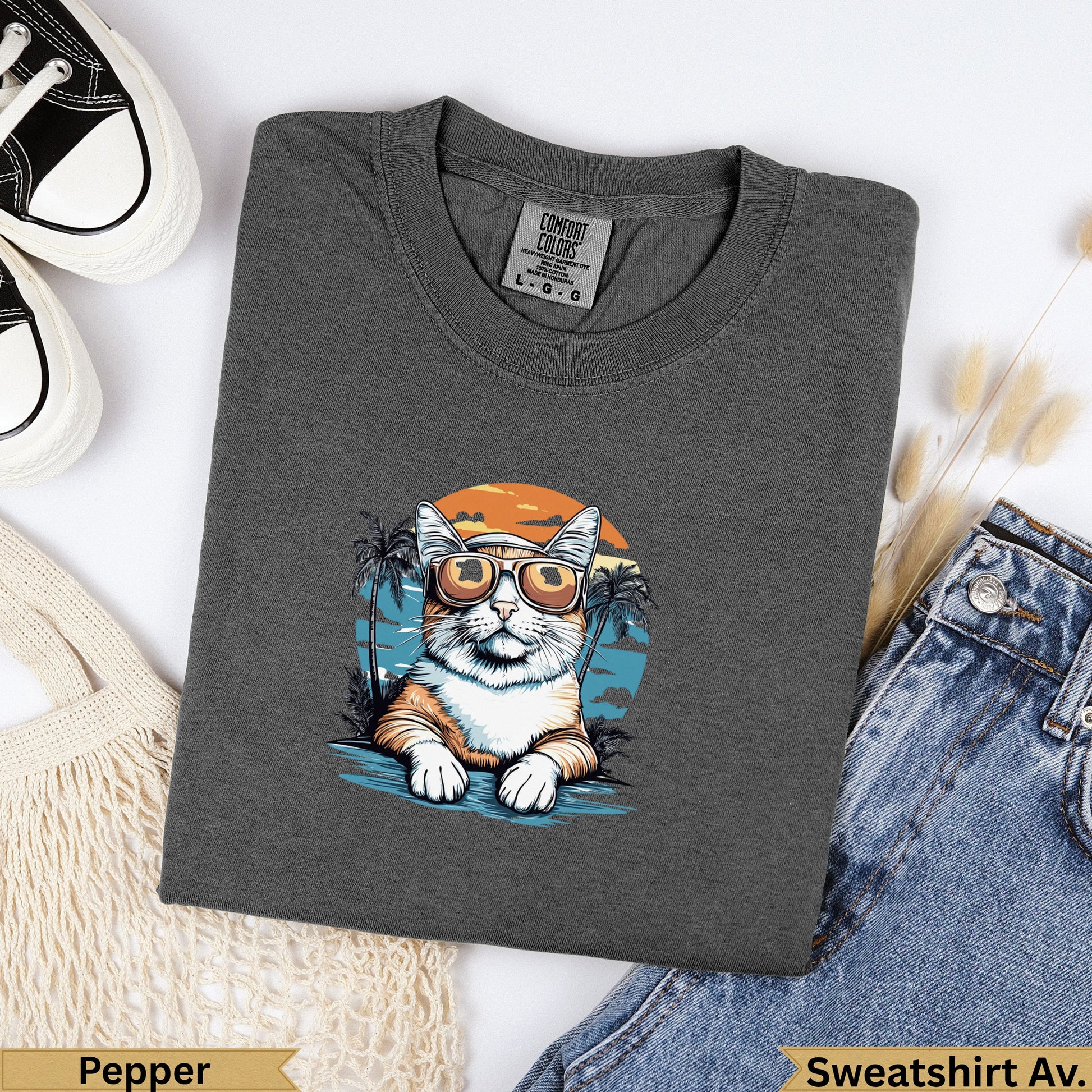 Dark grey Comfort Colors sweatshirt with a cartoon cat wearing sunglasses by the beach.