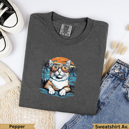Dark grey Comfort Colors sweatshirt with a cartoon cat wearing sunglasses by the beach.
