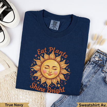 Navy crewneck sweatshirt with "Eat Plants Shine Bright" sun graphic.
