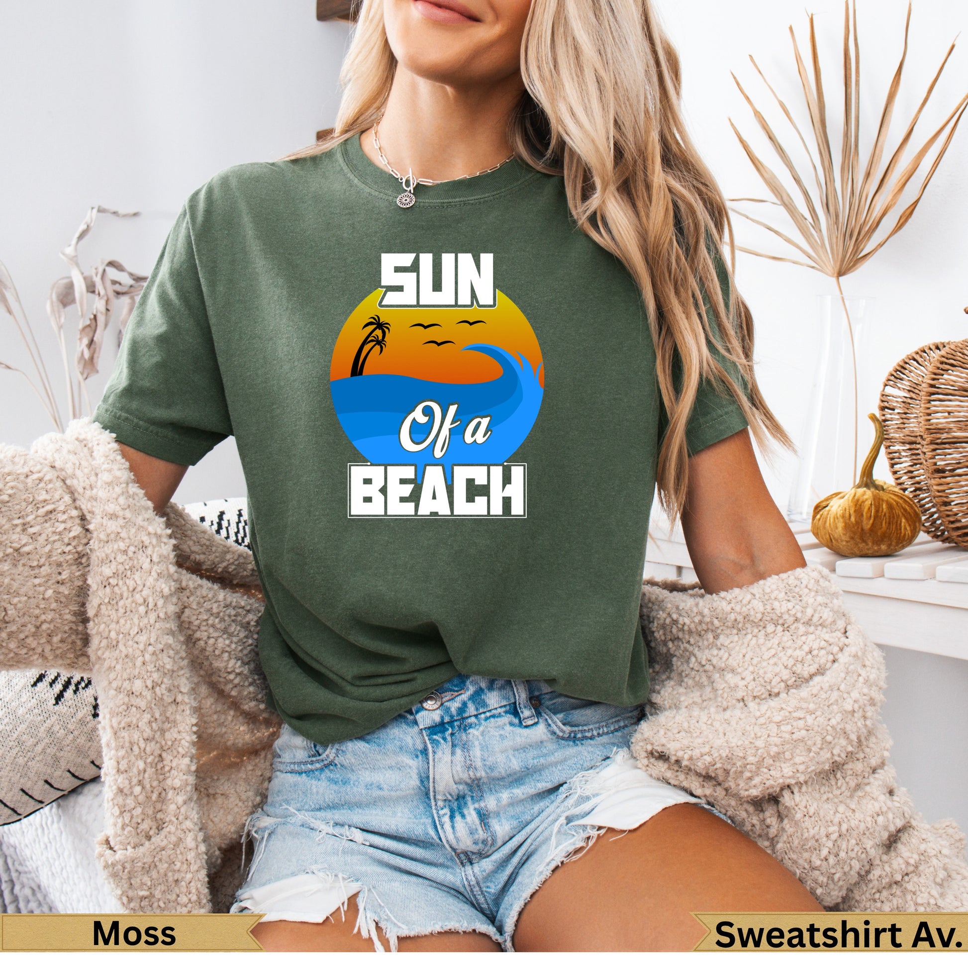 Green t-shirt with "SUN Of A BEACH" text and a sunset over waves.