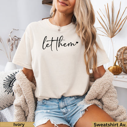 Cream graphic t-shirt with "let them" text, worn by a model.