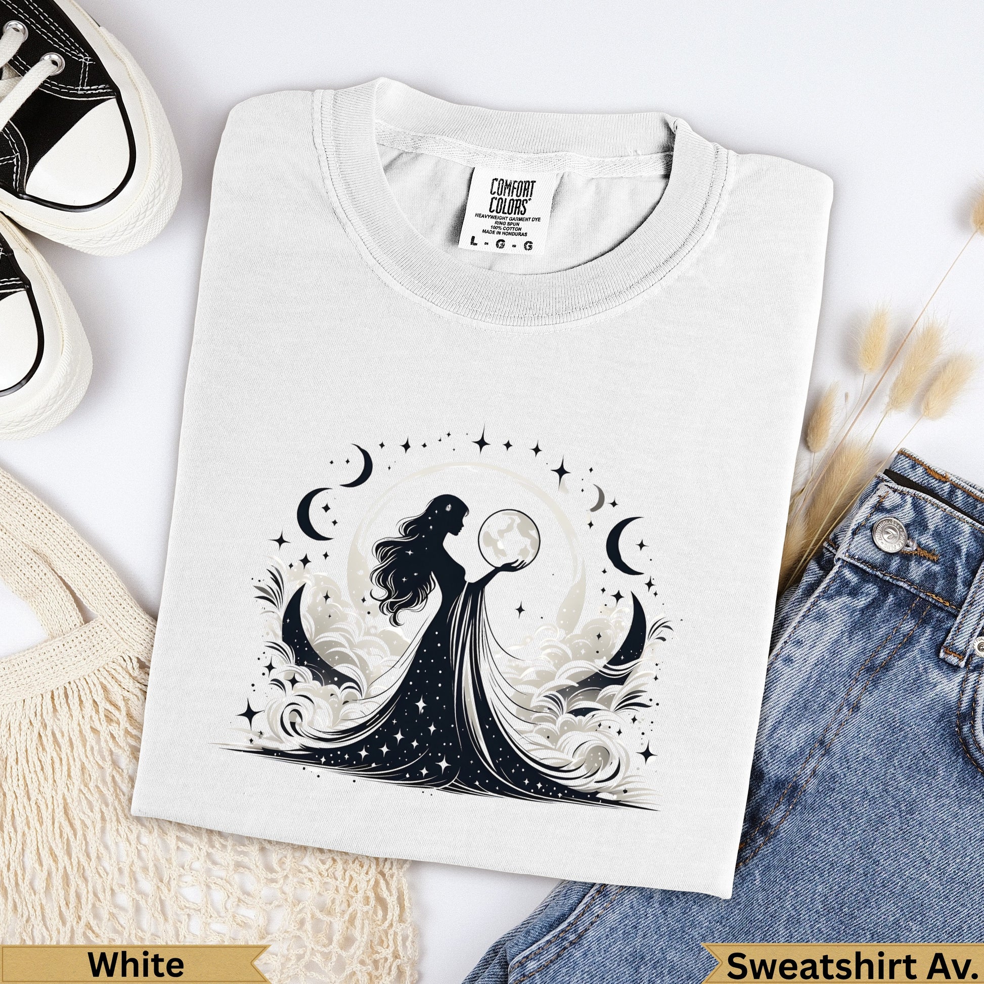 White graphic t-shirt with woman holding moon, surrounded by celestial elements.