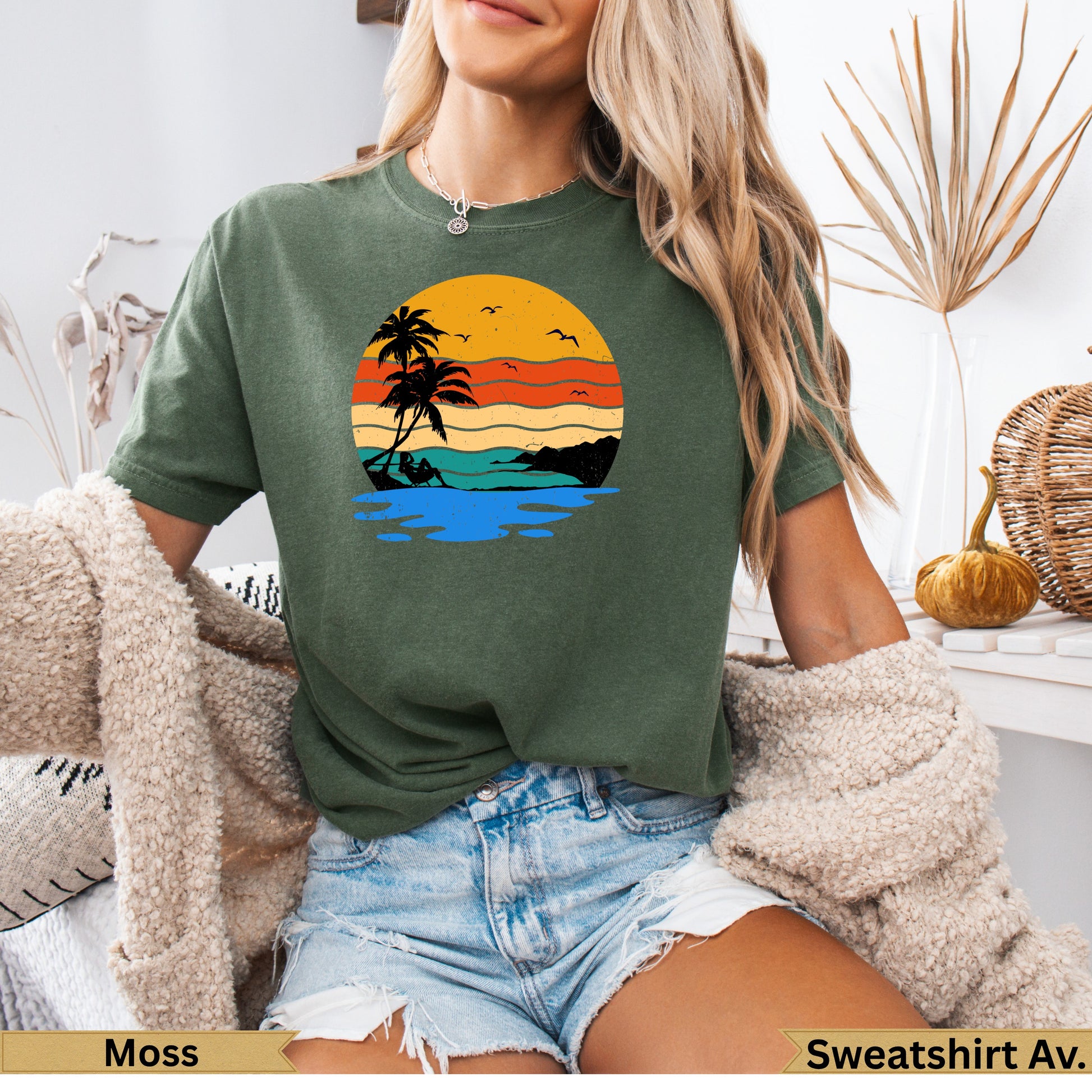 Green t-shirt with a sunset beach scene graphic.