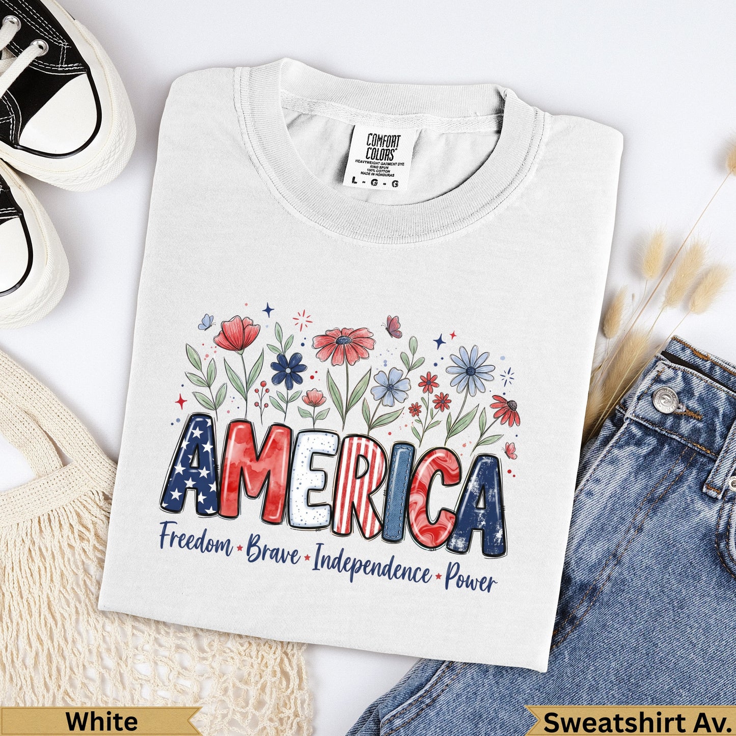 White Comfort Colors t-shirt with "AMERICA" in bold letters, surrounded by flowers and text.