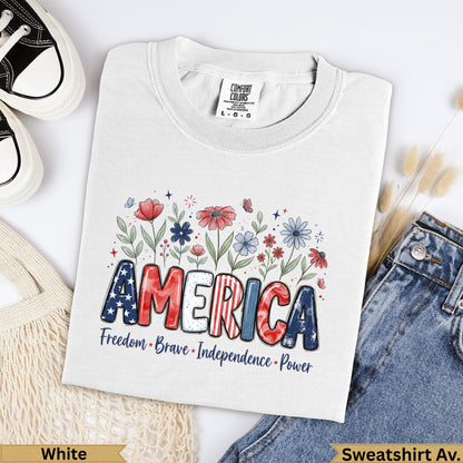 White Comfort Colors t-shirt with "AMERICA" in bold letters, surrounded by flowers and text.