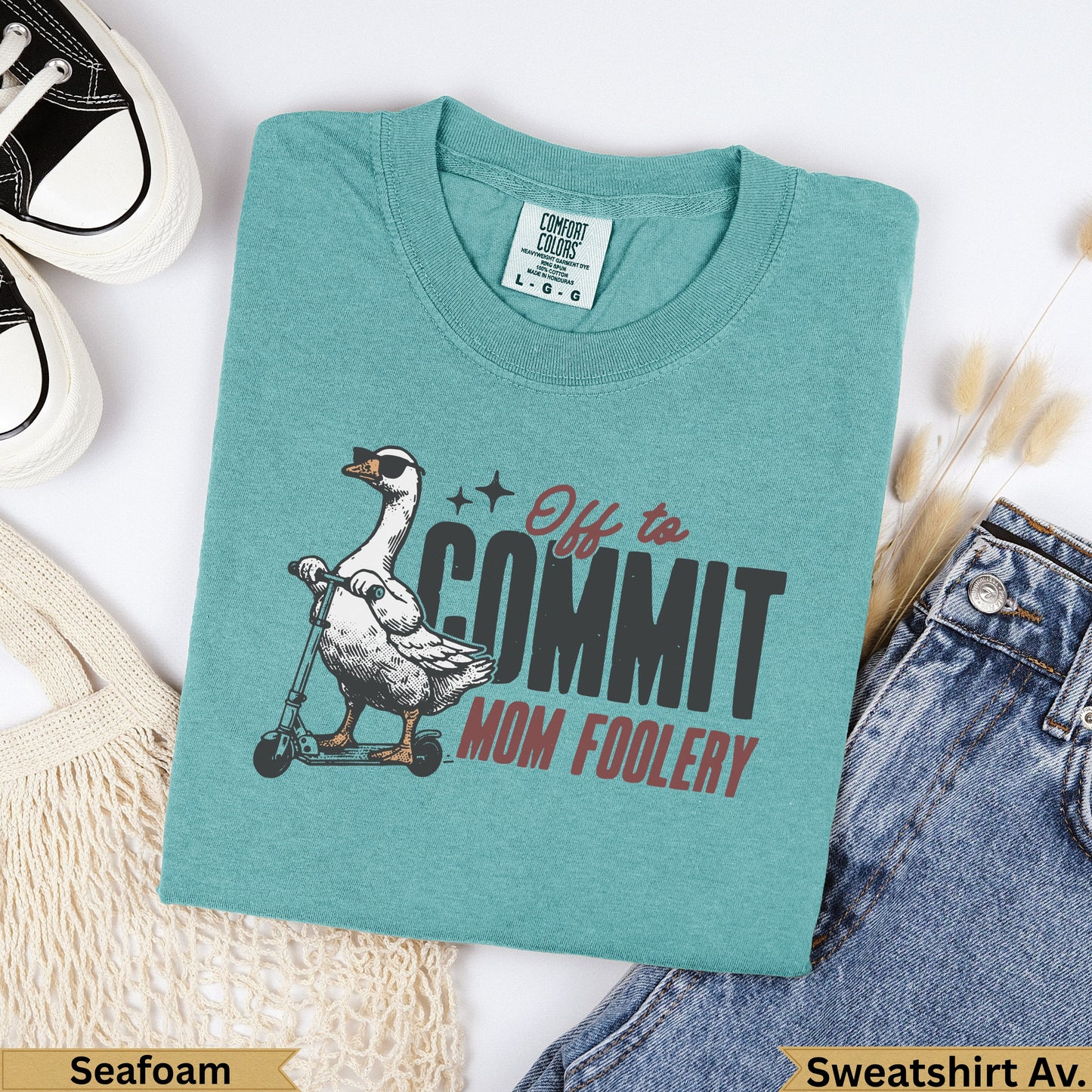 Teal Comfort Colors sweatshirt with a goose on a scooter saying "Off to Commit Mom Foolery."