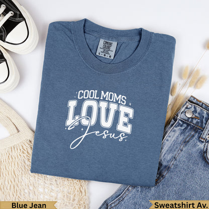 Blue t-shirt with "COOL MOMS LOVE Jesus" text, laid flat with jeans and shoes.