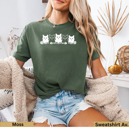 Green t-shirt with white line art cats and fishbones graphic.
