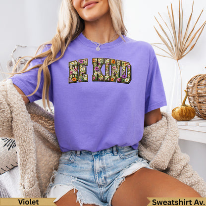 Purple t-shirt with "BE KIND" in floral lettering.