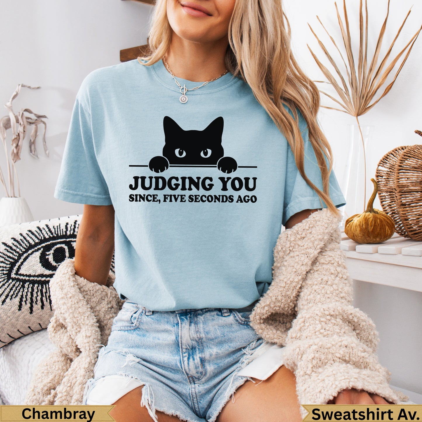Light blue t-shirt with black cat peeking over, text reads "JUDGING YOU SINCE, FIVE SECONDS AGO".