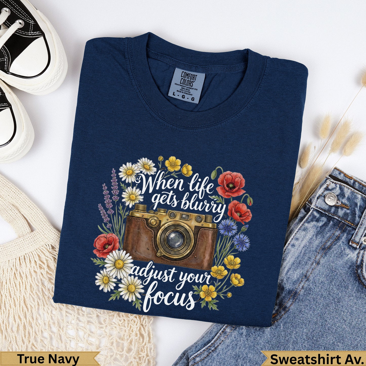 Navy t-shirt with camera, flowers, and "When life gets blurry adjust your focus" text.