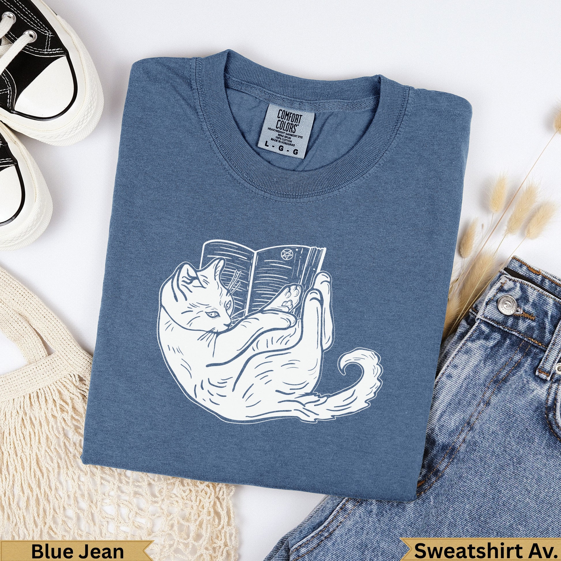 Blue Jean Comfort Colors sweatshirt with white cat reading a book graphic.