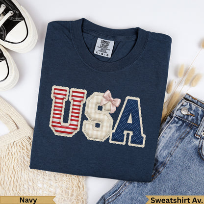 Navy Comfort Colors USA sweatshirt with checkered and striped letters and pink bow.
