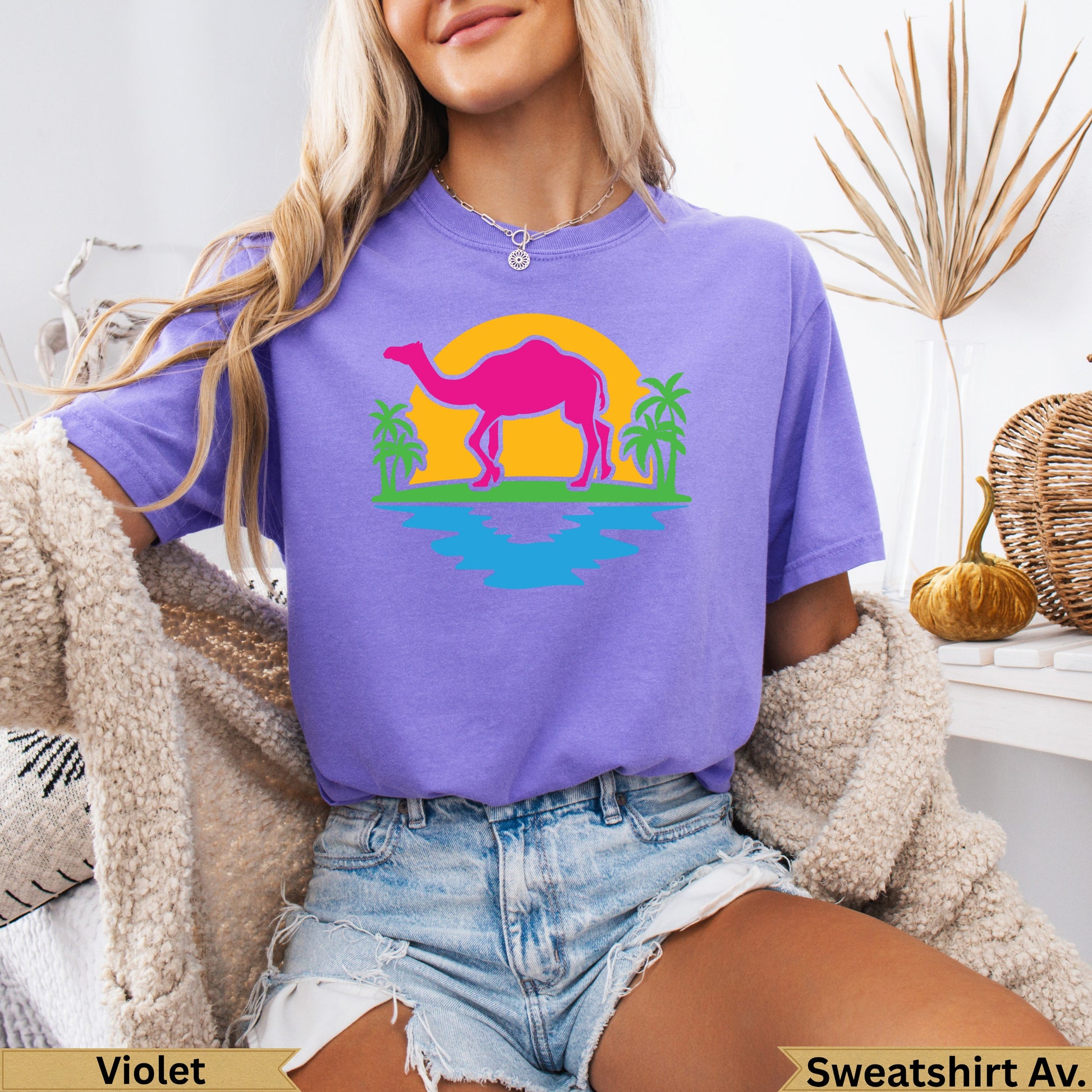 Purple t-shirt with pink sunset, palm trees, and blue water graphic.
