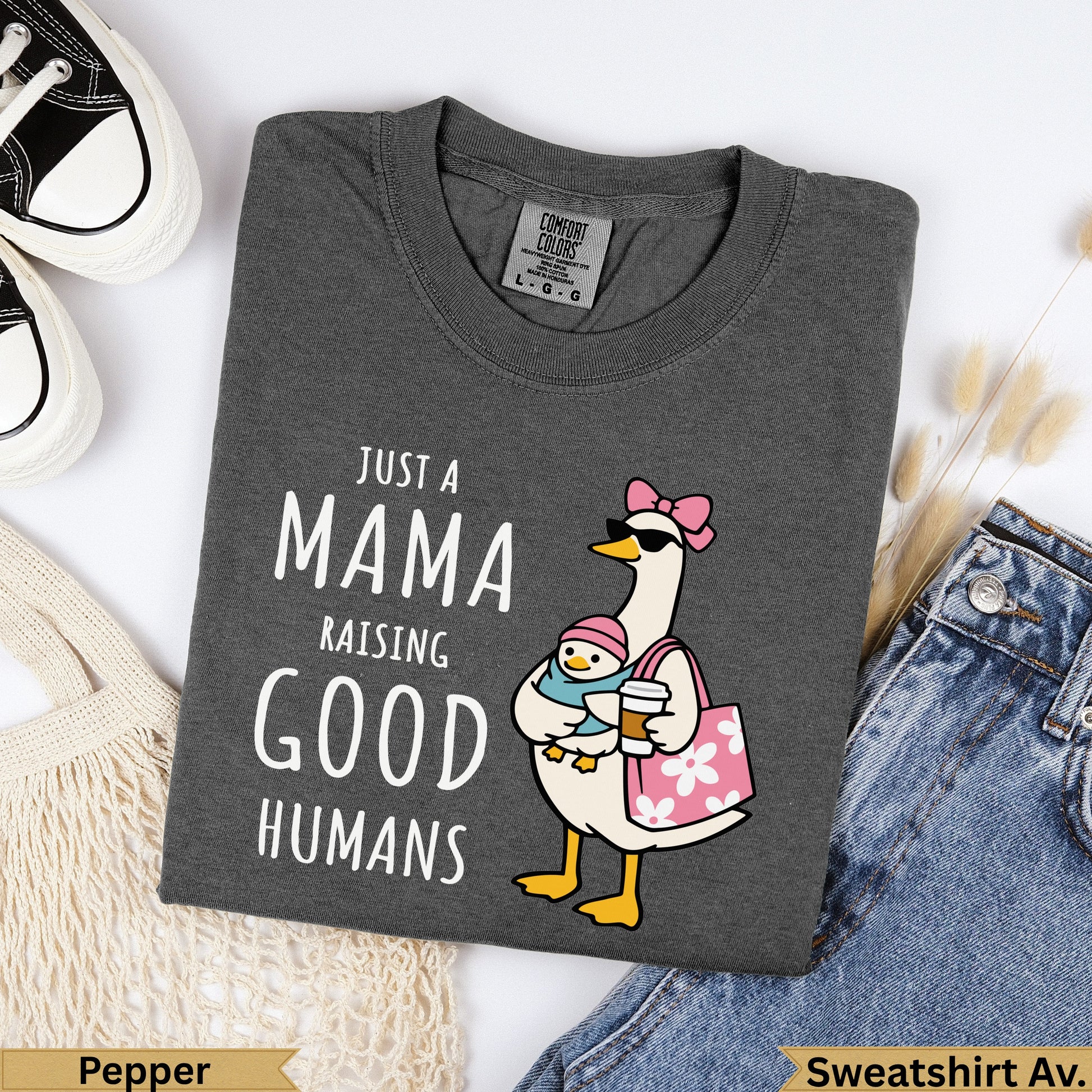 Dark gray t-shirt with "JUST A MAMA RAISING GOOD HUMANS" text and cartoon duckling.