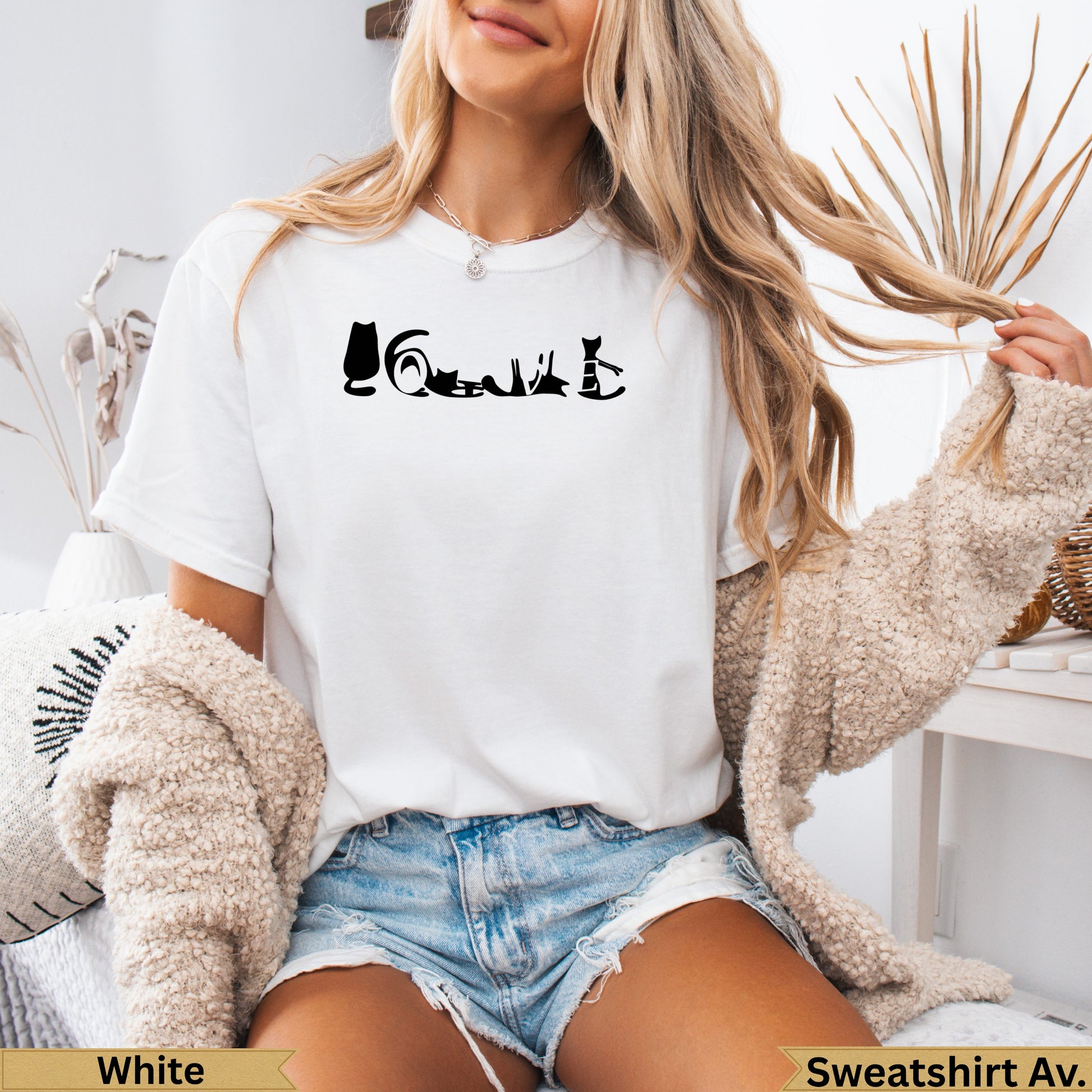 White t-shirt with silhouette of cats in various poses and "Sweatshirt Av." text.